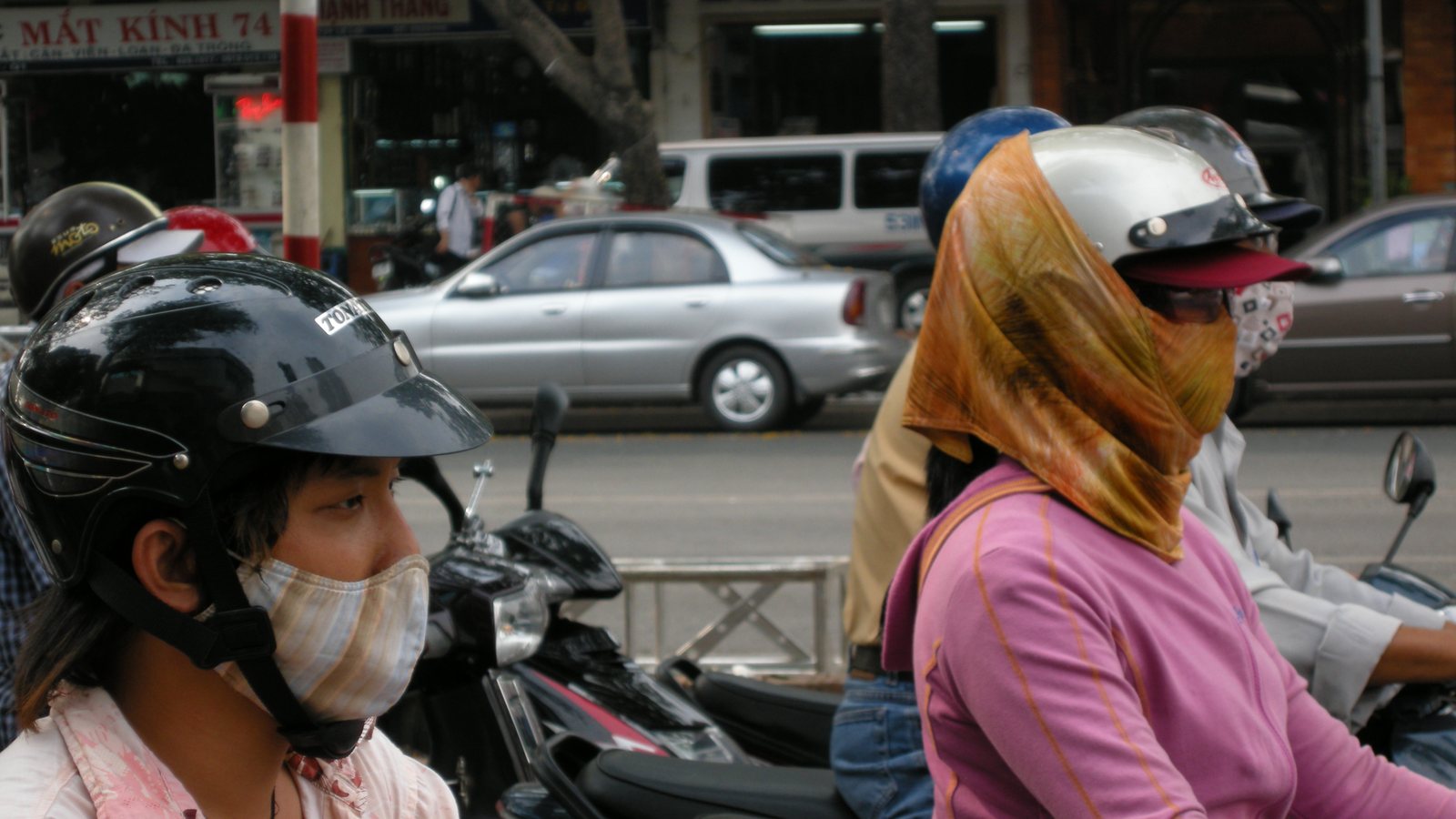 Ho Chi Minh City street traffic with motorbikes, storefronts, and dense urban movement