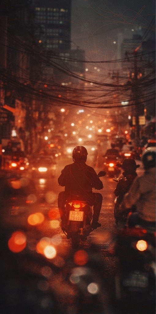 Scooters moving through a dense Vietnamese street at night